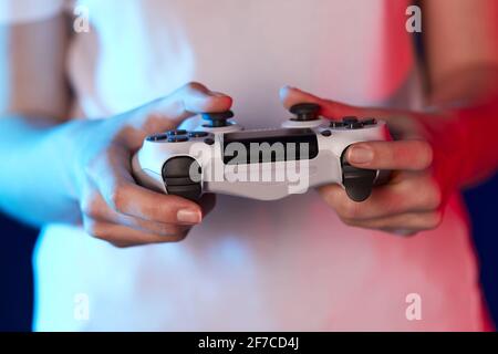 mani femminili che giocano a videogiochi sulla console Foto Stock