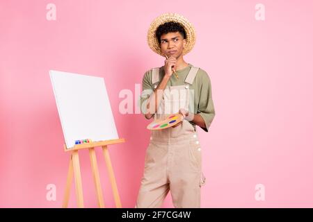 Ritratto fotografico del pittore afroamericano che pensa isolato su pastello sfondo di colore rosa Foto Stock