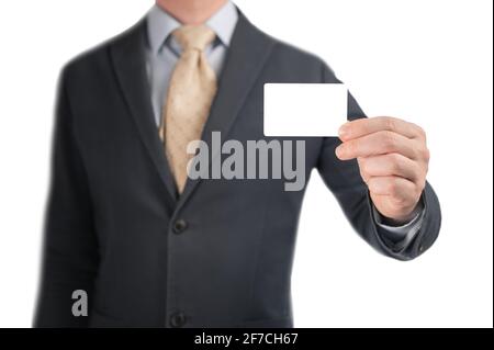 Mano che tiene il biglietto da visita vuoto. Bell'uomo d'affari in vestito nero che mostra la sua carta di credito mockup per effettuare un pagamento. Uomo tenendo e mostrando bianco b Foto Stock