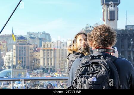 KIEV, UCRAINA - 13 MARZO 2014: Jared Leto guarda indietro, e il suo cameraman scatta le foto della città tenda che si erge sopra il Maidan Nezalezhnosti Foto Stock