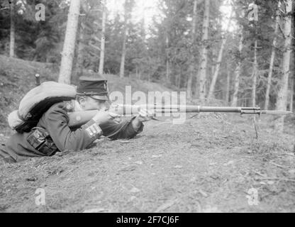 Ernst Axfors collezione 34 un soldato dell'esercito mette un fucile sdraiato su una collina. L'uomo è Ernst Axfors e appartenne nel 4 reggimento. Foto Stock
