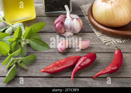 Peperoncini rossi e altri condimenti su tavola di legno. Foto Stock