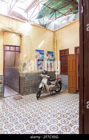 Tipico scooter in un cortile splendidamente piastrellato a Marrakech, Marocco Foto Stock