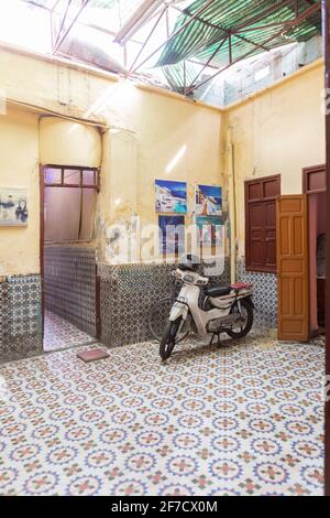 Tipico scooter in un cortile splendidamente piastrellato a Marrakech, Marocco Foto Stock