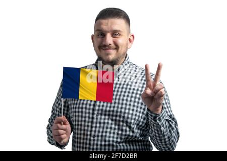 Ragazzo bianco che tiene una bandiera del Ciad e mostra due dita isolate su uno sfondo bianco. Foto Stock