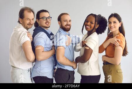 Studio ritratto di gruppo di persone felici e diverse che mostrano le armi dopo ottenere il vaccino Foto Stock