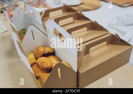 Molti contenitori per cibo da asporto, scatola per pizza, tazze da caffè e sacchetti di carta su sfondo grigio chiaro. Consegna di cibo Foto Stock