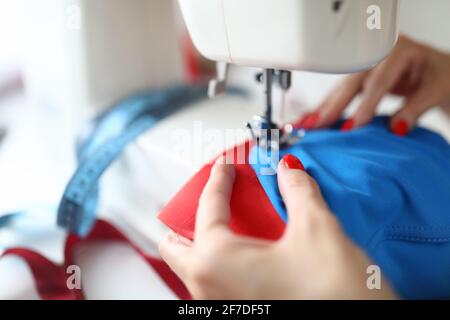 Primo piano di una donna su misura professionista che lavora su cucito elettrico bianco macchina Foto Stock