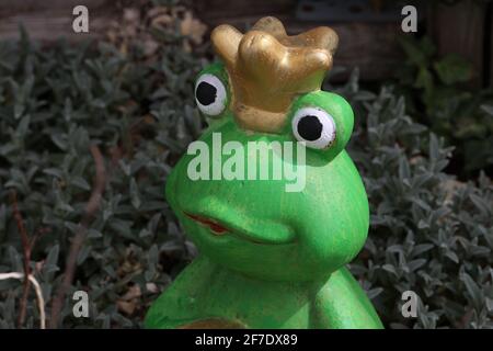 Principessa di rana decorativa tra piante nel giardino. Foto Stock