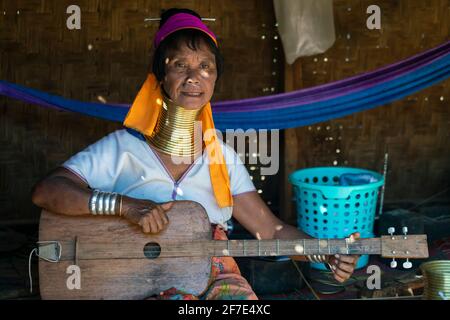 Donna della tribù Kayan che suona la chitarra a quattro corde, Loikaw, Myanmar Foto Stock