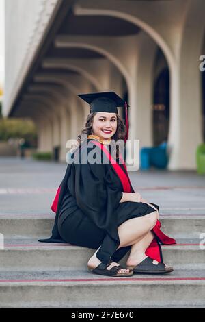 Giovane donna laureata college, indossando un abito di laurea / tappo. Foto Stock