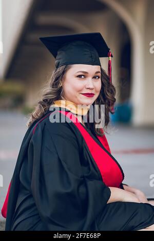 Giovane donna laureata college, indossando un abito di laurea / tappo. Foto Stock