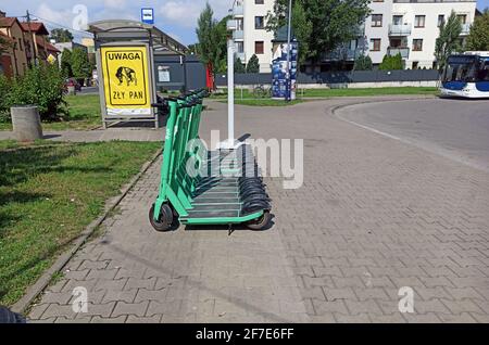 Cracovia, Polonia - 05 maggio 2021: Scooter elettrici verdi dalla società Bolt in affitto parcheggiati in linea nella città di fronte alla stazione degli autobus durante il giorno. Foto Stock