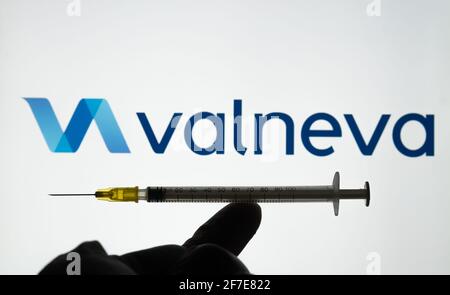Concetto di vaccino Valneva COVID-19. Il logo della siringa e della società Valneva sullo schermo di sfondo sfocato. Stafford, Regno Unito, 6 aprile 2021. Foto Stock