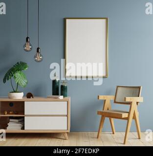 Poster mockup con cornici verticali su parete vuota blu scuro Interno in soggiorno con poltrona.rendering 3D Foto Stock