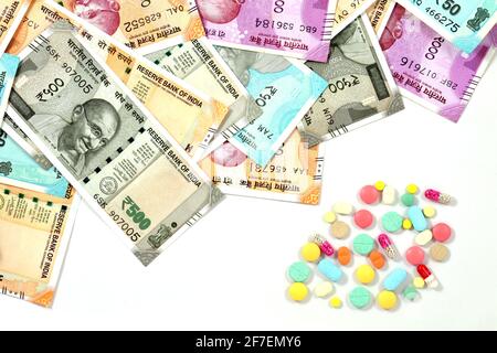 Pila di farmaco farmaceutico, pillole di medicina e denaro indiano, costo di salute e concetto di assicurazione medica Foto Stock