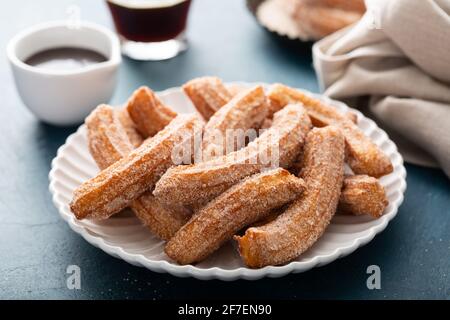 Churros fatti in casa con zucchero alla cannella su un piatto Foto Stock