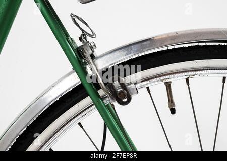 Una vecchia bicicletta verde vintage di aspetto retrò per le donne, isolato o sfondo bianco. Dettaglio del freno posteriore con pastiglie dei freni e valvola presta visibile. Foto Stock