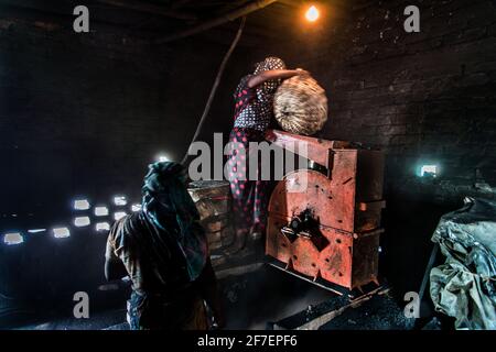 Un lavoro femminile lavora sul carbone in un campo di mattoni a Khulna, Bangladesh. Foto Stock