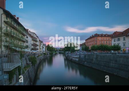 Rive del fiume di Ljubljanica con case colorate durante le prime ore della sera. Ora blu visto dal ponte di Lubiana, guardando verso sud Foto Stock