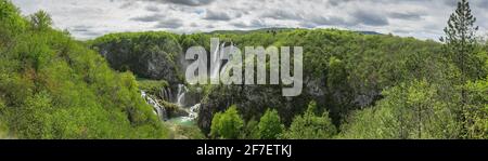 Vista panoramica della cascata più grande chiamata veliki Srap nei laghi di plitvice, croazia in una giornata nuvolosa di primavera. Grande cascata circondata da verdi lussureggianti Foto Stock
