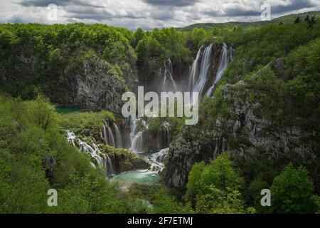 Vista panoramica della cascata più grande chiamata veliki Srap nei laghi di plitvice, croazia in una giornata nuvolosa di primavera. Grande cascata circondata da verdi lussureggianti Foto Stock
