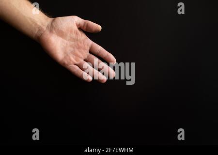 mano di un uomo su sfondo nero. Foto Stock