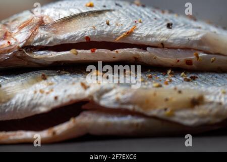 pancia di pesce marinata con spezie per cucinare da vicino Foto Stock