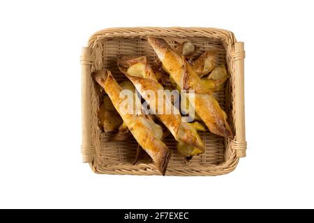 Lotto di taquitos appena sfornati in un cesto di vimini che serve, su uno sfondo bianco isolato. Gustoso spuntino messicano appena sfornato. Vista dall'alto Foto Stock