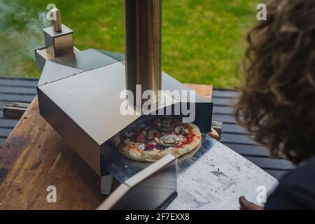 A legna pietra pizza cotta al forno a pale Foto stock - Alamy