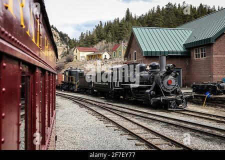 Locomotiva a vapore della ferrovia a loop Georgetown in Colorado, Stati Uniti. Il motore è parcheggiato in un deposito, guardando da un altro pullman. Foto Stock