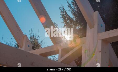 Particolare di moderno telaio o cornici in legno, struttura con traliccio su una casa ristrutturata. Albero e sunflare sullo sfondo Foto Stock