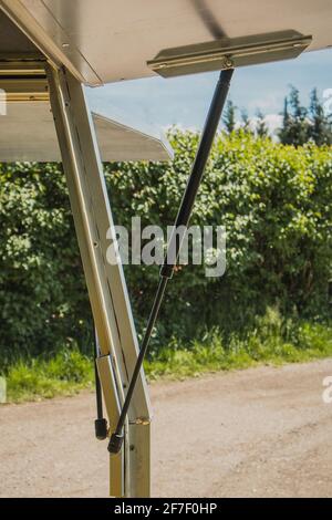 Sollevatore o assorbitore a pressione riempito di gas, installato su una porta o un telaio industriale in metallo. Due alzavighe a gas sulla porta di un camion. Foto Stock