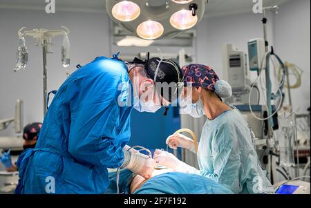 i medici lavorano sodo nella sala operatoria Foto Stock