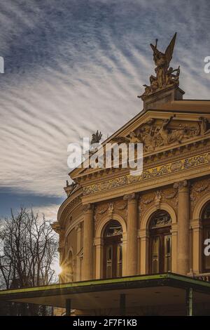 Bellissimo teatro lirico a Lubiana, slovenia, al tramonto. Particolare della facciata anteriore con sole che solo invia raggi di luce alla parete laterale. Nizza clou Foto Stock