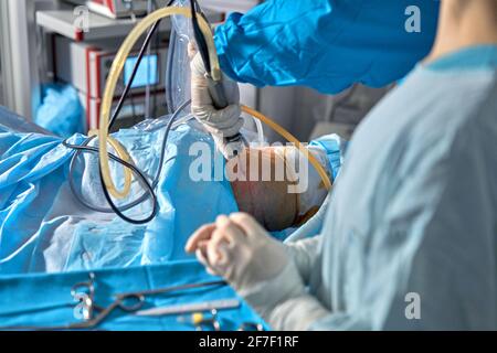 Medico che cerca di risolvere un trauma articolare del ginocchio. Foto Stock