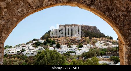 L'Acropoli di Lindian sorge su case bianche nel villaggio di pescatori di Lindos, a Rodi, in Grecia. L'antica cittadella greca e luogo di culto è se Foto Stock