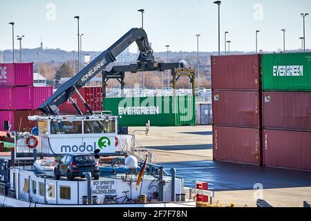 Wolfsburg, Germania, 21 febbraio 2021: Nel porto di Fallersleben, una gru a container scarica i container di carico di una nave da carico per la fabbrica di automobili in WO Foto Stock