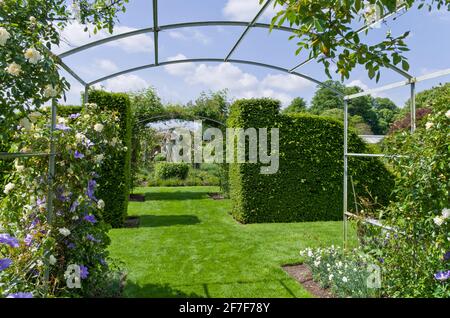 Houghton Hall Gardens in estate, Norfolk, Regno Unito; bordi dei fiori, siepi e una statua nel giardino murato. Foto Stock