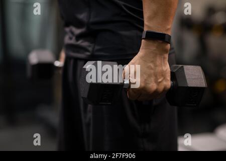 Uomo maturo che lavora con pesi a mano in palestra Foto Stock