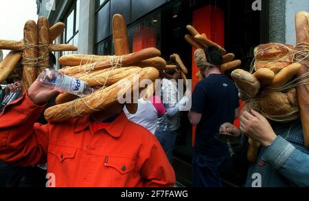 Japanease artista Tatsumi Origoto maggio 2001, conduce una sfilata di persone con pani di pane lungo Oxford Street, fuori Selfridges per coincidere con la vita di Tokyo. Tatsumi Origoto è sulla destra. Foto Stock