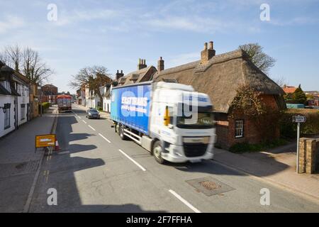 Fila di cottage con tetto di paglia in Alford Lincolnshire con traffico pesante Foto Stock