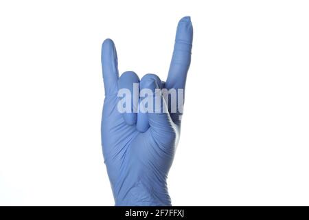 Il guanto medico Hand in mostra un gesto rock, isolato su sfondo bianco Foto Stock