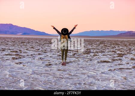 Modello in posa per la fotocamera al tramonto sulle saline delle dune di Mesquite, California, Stati Uniti d'America, Nord America Foto Stock