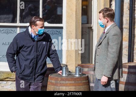 Grassington, Regno Unito. 7 aprile 2021. Nicholas Ralph (James Herriot) e Callum Woodhouse (Tristan Farnon) provano una scena indossando maschere durante le riprese per la seconda serie del Channel 5 re-make of All Creatures Great and Small si svolge nel villaggio di Grassington nello Yorkshire Dales Nation Park. (Credit: Tom Holmes Photography / Alamy Live News) Foto Stock