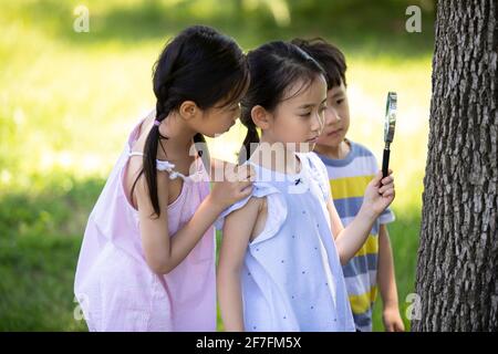 Felici i bambini che giocano nel parco Foto Stock