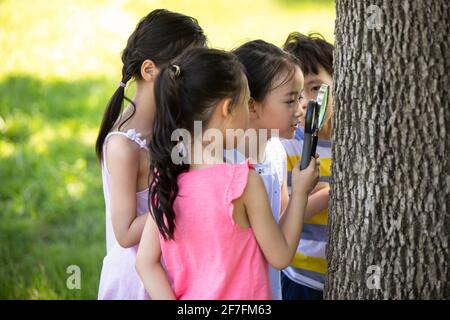 Felici i bambini che giocano nel parco Foto Stock