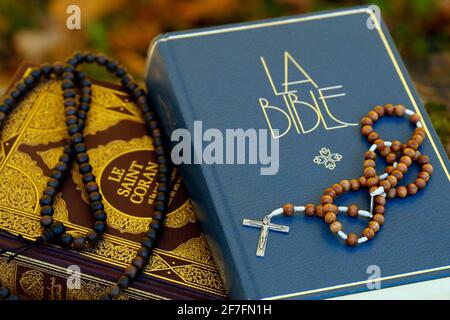 Santo Corano in francese con perle di preghiera musulmane e Bibbia con rosario, simboli interreligiosi tra cristianesimo e Islam, Francia, Europa Foto Stock