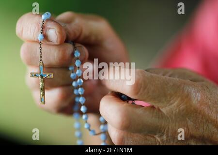 Primo piano delle mani di un uomo che prega il rosario, Francia, Europa Foto Stock