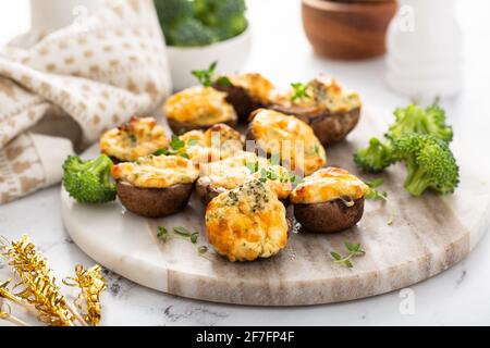 Funghi farciti con broccoli e ripieno di formaggio Foto Stock